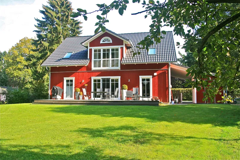 Frontansicht der Villa Herregård in Dassendorf – klassisches Schwedenhaus in Herrenhausarchitektur mit eleganter Holzfassade und weißen Sprossenfenstern.